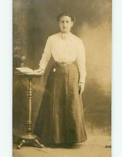 1910 rppc WOMAN BY ANTIQUE WOODEN BOOK STAND postcard v1193