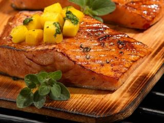 salmon being cooked on a truefire gourmet grilling plank